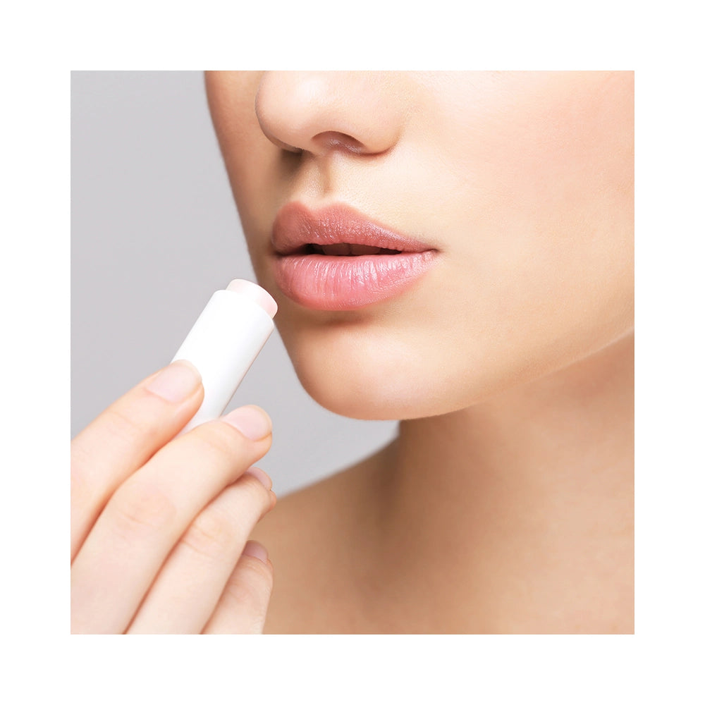Nainen levittää Nathalie Lip Balm -huulivoidetta kuiville ja rohtuneille huulille
